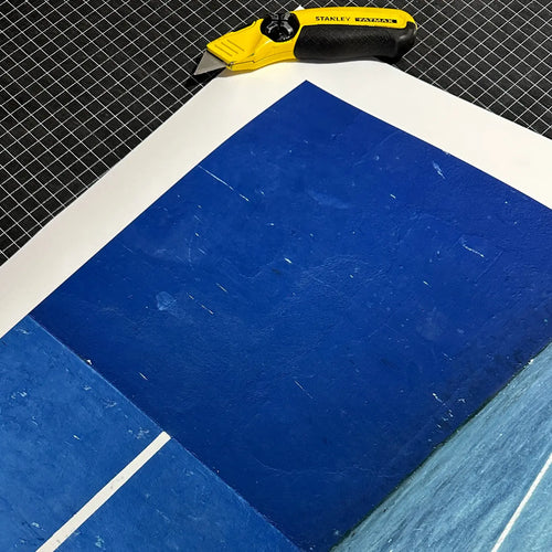 Papel Canson Edition Etching Rag 310g con diseño azul profundo y cuchillo amarillo sobre rejilla