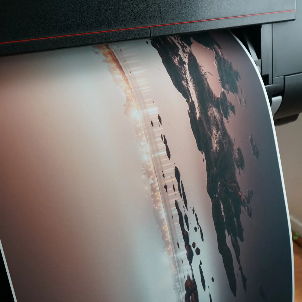 Papel Canson Etching Rag 310g grano fino con fotografía de ciudad saliendo de impresora gran formato
